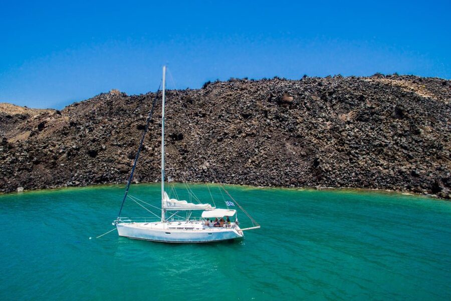 Santorini Caldera: Sunset Sailing Cruise with Meal - Sailing past the lighthouse and into the caldera